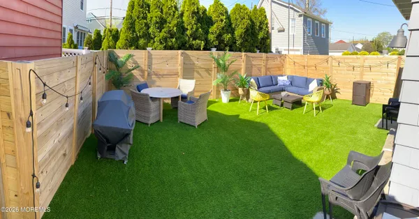 a backyard of a house with table and chairs
