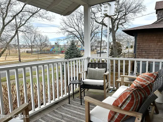 a view of roof deck with couches and wooden fence