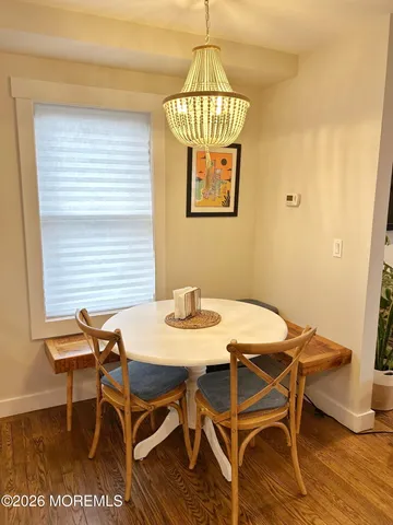 a view of a dining room with furniture wooden floor and chandelier
