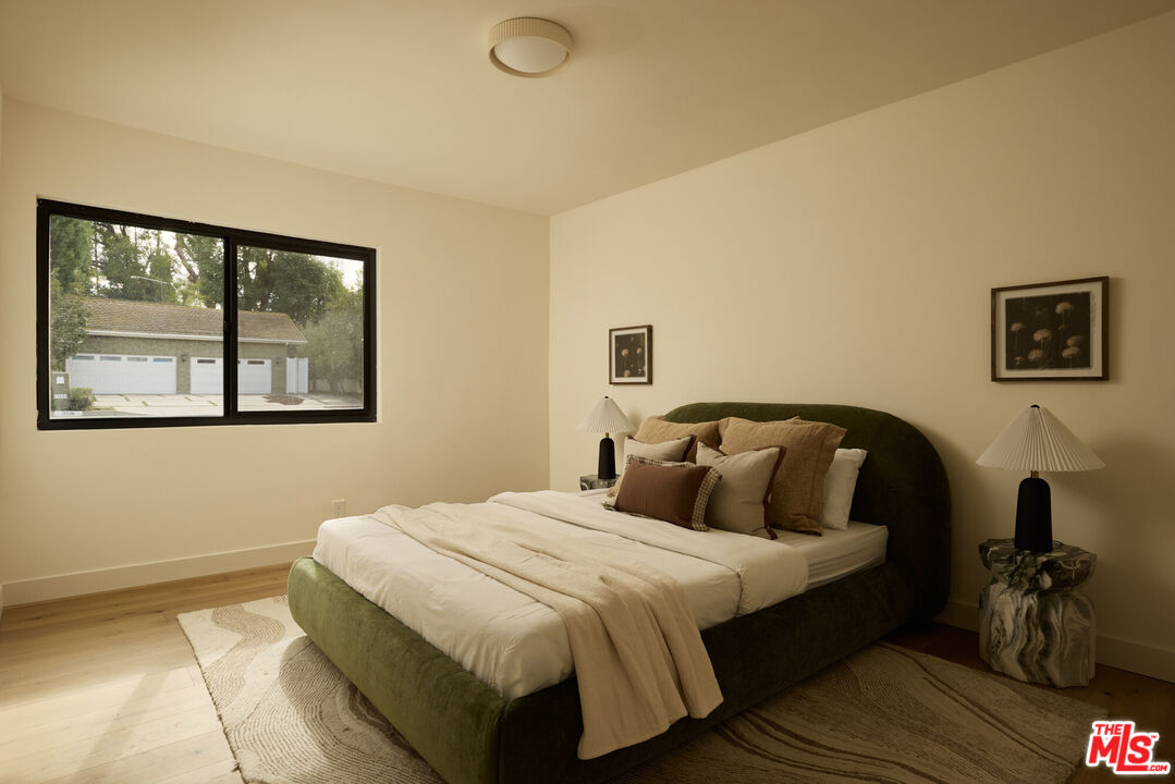 17539 West Magnolia Boulevard Encino, CA 91316 - Photo 23 of 31 a bedroom with a bed and wooden floor