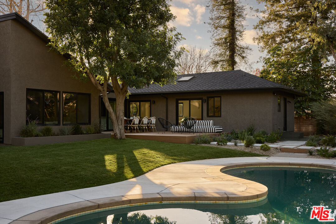 17539 West Magnolia Boulevard Encino, CA 91316 - Photo 25 of 31 a view of a house with swimming pool and a yard