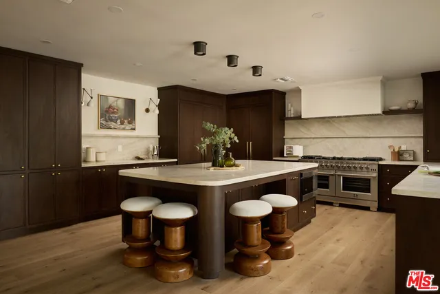 a kitchen with stainless steel appliances granite countertop a stove a sink and a refrigerator