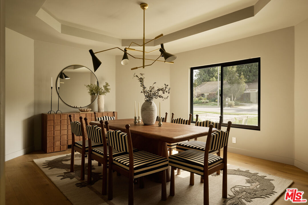 17539 West Magnolia Boulevard Encino, CA 91316 - Photo 10 of 31 a dining room with furniture a chandelier and window