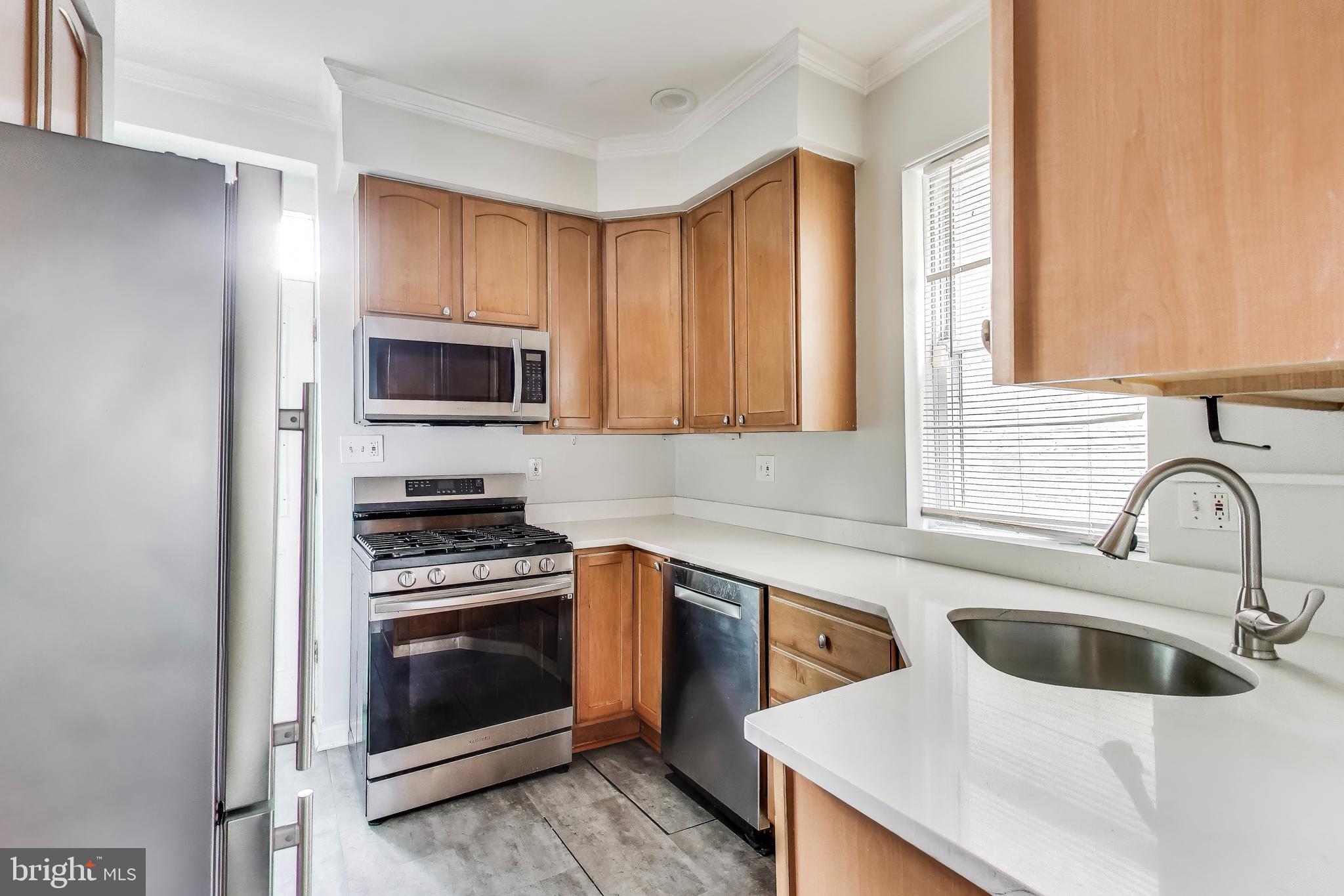 1327 1st Street Northwest Washington, DC 20001 - Photo 5 of 18 a kitchen with stainless steel appliances a stove a sink a window and cabinets