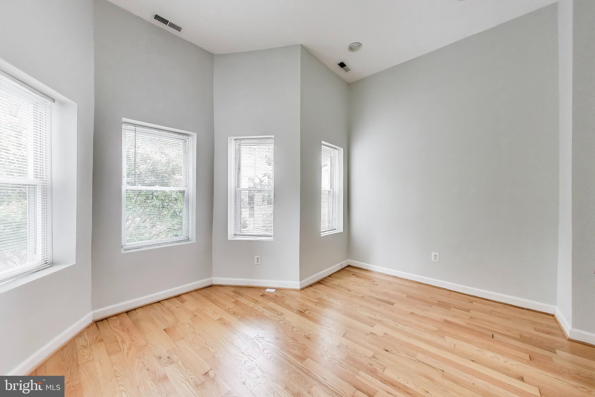 1327 1st Street Northwest Washington, DC 20001 - Photo 9 of 18 a view of an empty room with wooden floor and a window
