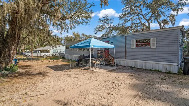 a view of a house with backyard and sitting area