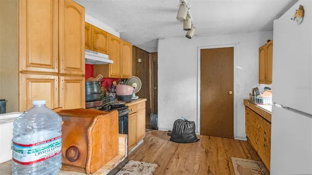 a kitchen with a sink and wooden floor