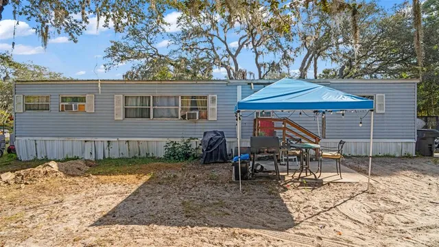 a view of a house with backyard and chairs