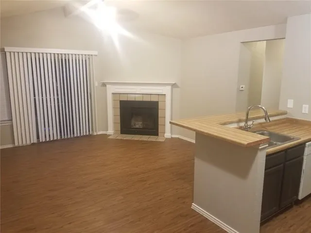 a view of an empty room with a fireplace and a window