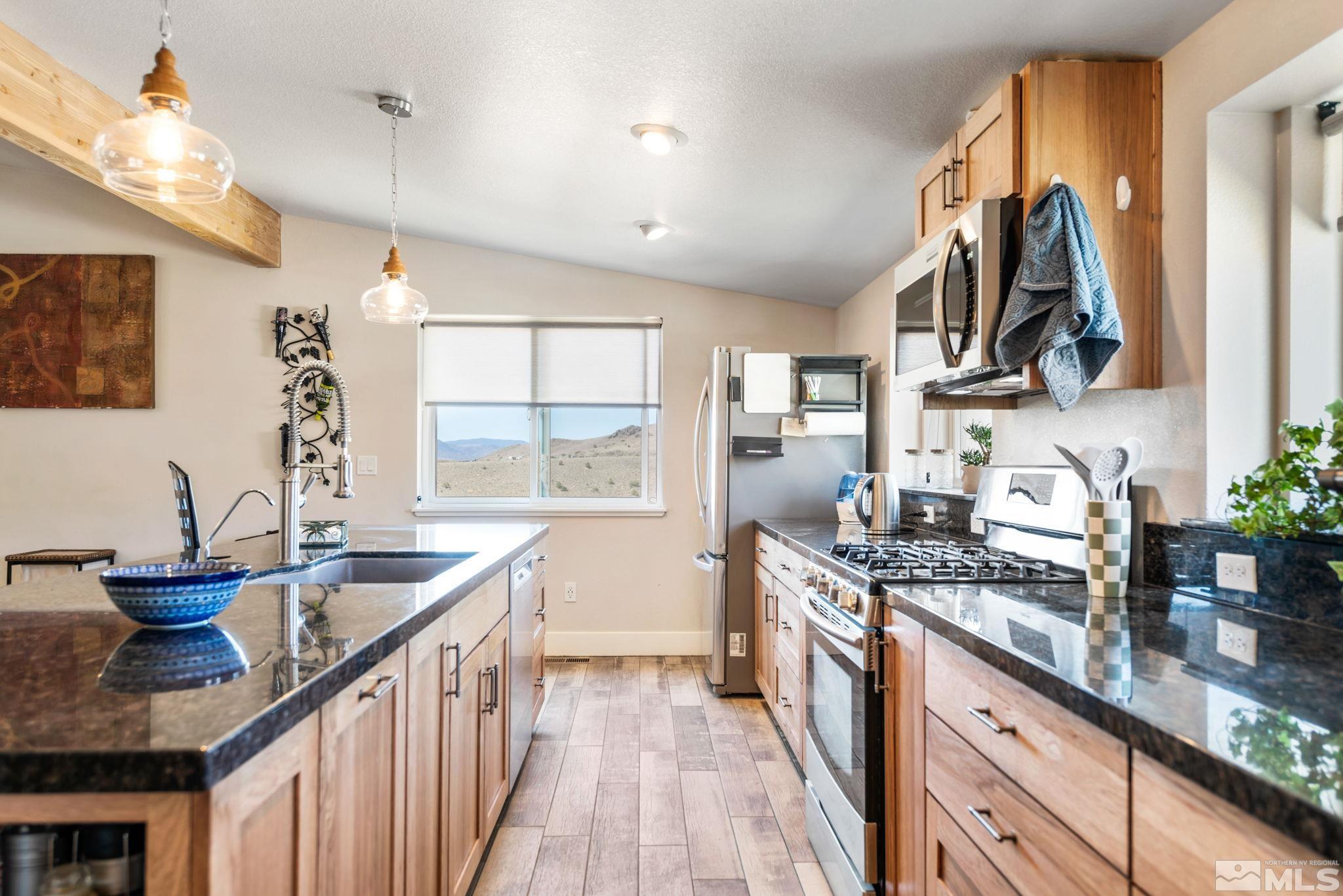 205 Eagle Vw Trail Dayton, NV 89403 - Photo 14 of 40 a kitchen with stainless steel appliances granite countertop a sink and a stove