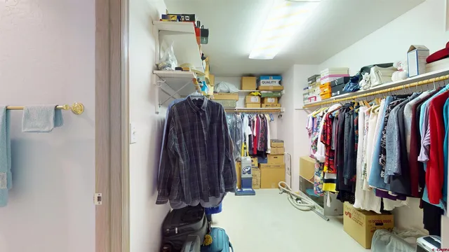 a view of walk in closet with clothes and shoes