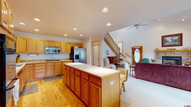 a large kitchen with stainless steel appliances kitchen island granite countertop a large counter top and a stove top oven