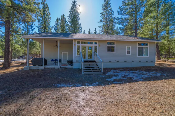 a view of a house with backyard and chairs