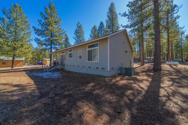 a view of a house with backyard and trees