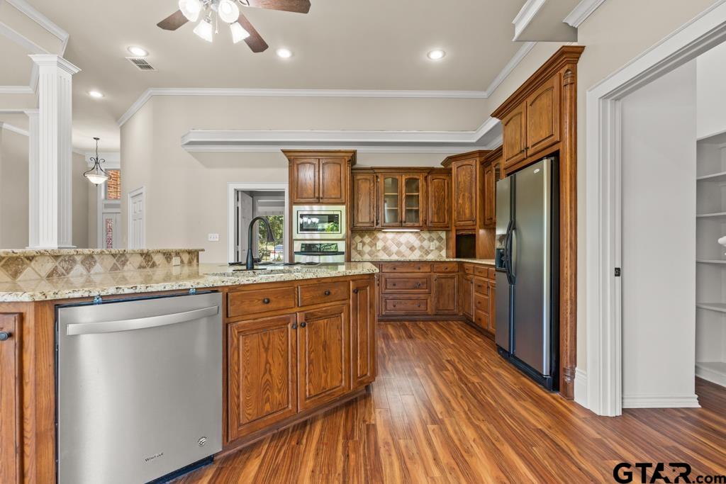 100 Lantana Road Gilmer, TX 75644 - Photo 12 of 30 a kitchen with stainless steel appliances granite countertop a refrigerator a sink dishwasher a stove and white countertops with wooden floor