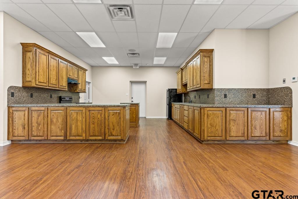100 Lantana Road Gilmer, TX 75644 - Photo 27 of 30 a large kitchen with stainless steel appliances granite countertop a large stove a sink dishwasher and a microwave oven with wooden floor