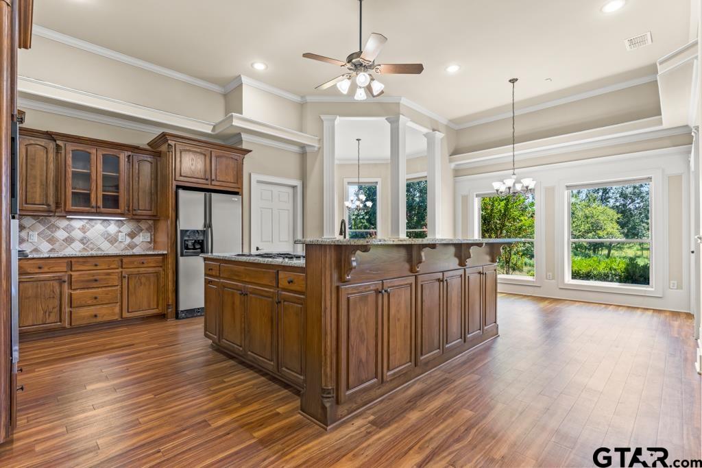 100 Lantana Road Gilmer, TX 75644 - Photo 9 of 30 a kitchen with stainless steel appliances granite countertop a stove a sink dishwasher and white cabinets with wooden floor