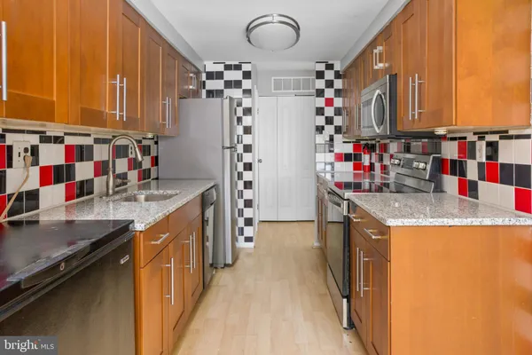 a kitchen with kitchen island granite countertop a sink and cabinets