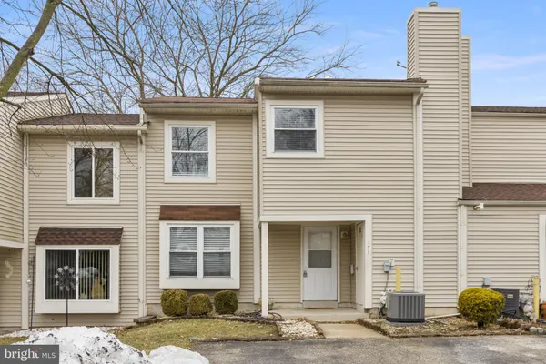 a front view of a house with a lots of windows and plants