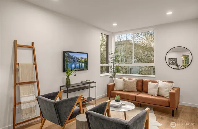a living room with furniture a large window and a flat screen tv
