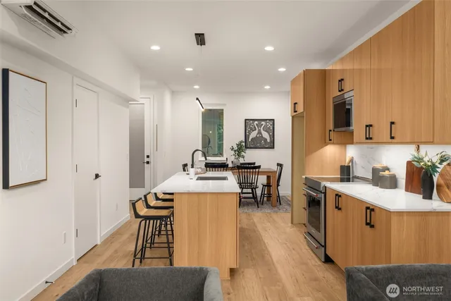 a living room with stainless steel appliances kitchen island granite countertop furniture a sink a rug and a window
