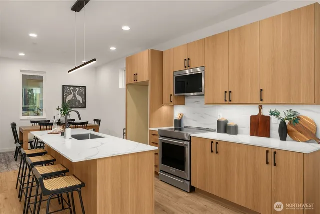 a kitchen with a sink a stove a refrigerator and chairs