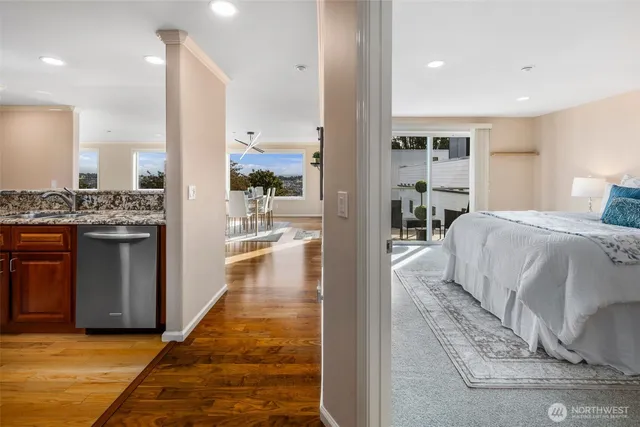 a living room with kitchen view and a wooden floor