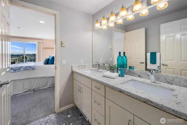 a bathroom with double vanity and a mirror