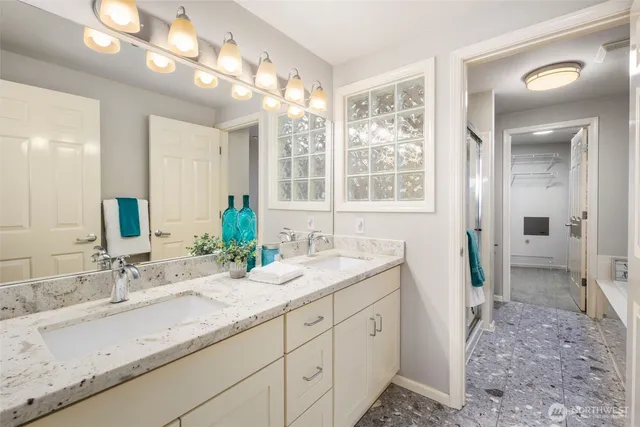 a bathroom with double vanity and a mirror
