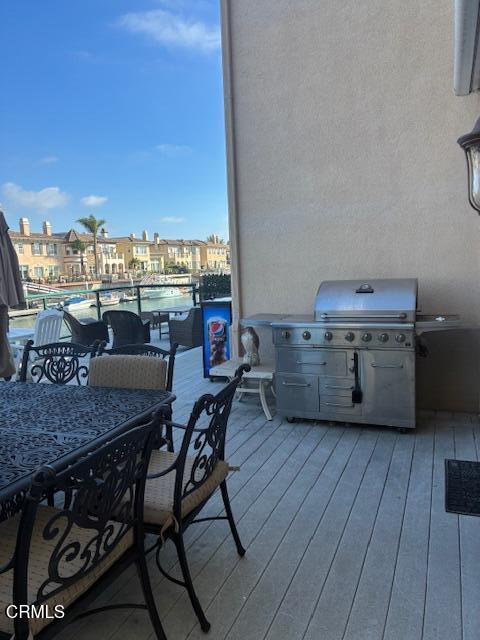 1470 Viewpoint Drive Oxnard, CA 93035 - Photo 19 of 23 a view of a roof deck with table and chairs a barbeque with wooden floor and city view