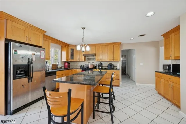 a kitchen with stainless steel appliances granite countertop a sink a stove and a refrigerator