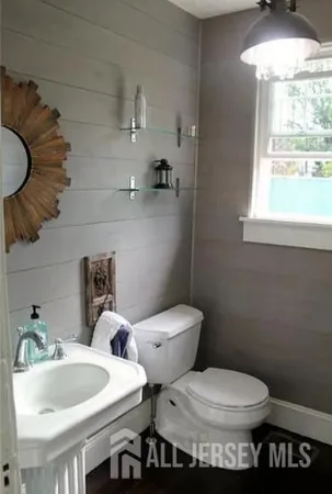 a bathroom with a sink a toilet and mirror