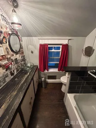 a bathroom with a sink a toilet a mirror and shower
