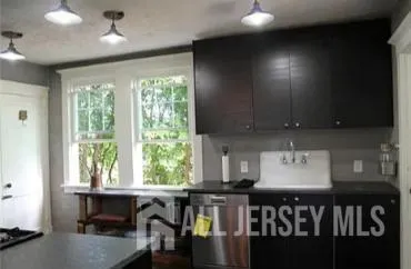 a kitchen with kitchen island granite countertop a stove a sink and a dining table with wooden floor