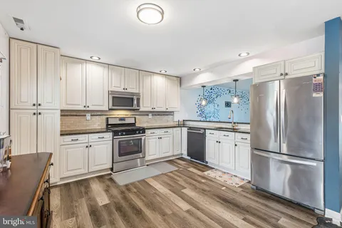 a kitchen with granite countertop a refrigerator stove and microwave