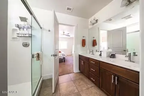 a spacious bathroom with a double vanity sink a mirror and shower