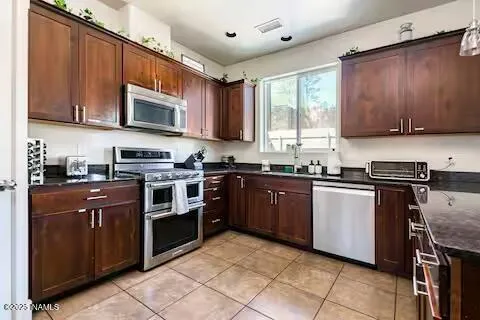 a kitchen with stainless steel appliances granite countertop wooden cabinets a stove top oven a sink and dishwasher