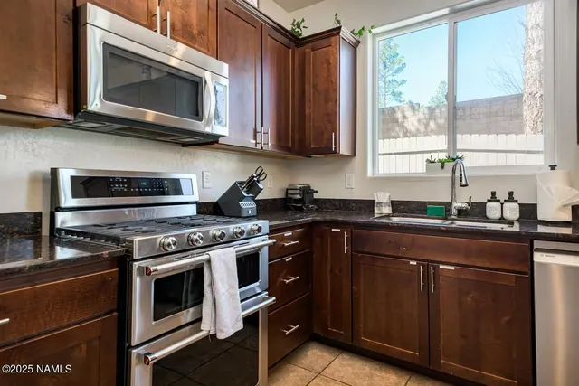 a kitchen with stainless steel appliances granite countertop a stove microwave and sink