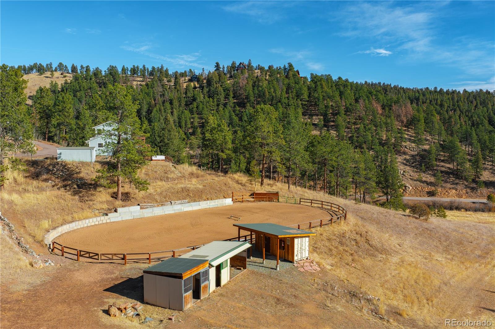 0 South Geronimo Trail Conifer, CO 80433 - Photo 14 of 34 a view of a swimming pool with lawn chairs under an umbrella