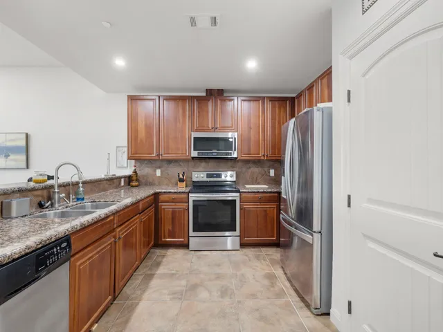 a kitchen with stainless steel appliances granite countertop a refrigerator stove and sink