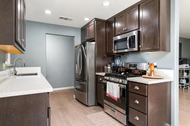 a kitchen with stainless steel appliances granite countertop a sink stove and refrigerator