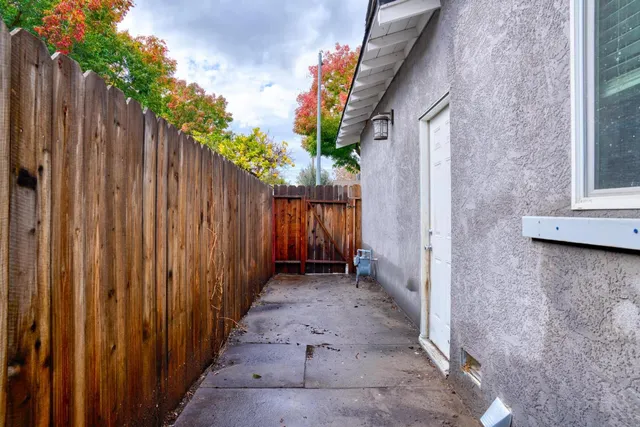 a view of a pathway of a house with wooden fence