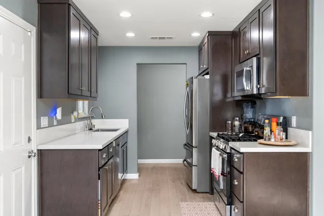 a kitchen with stainless steel appliances granite countertop a sink refrigerator and cabinets