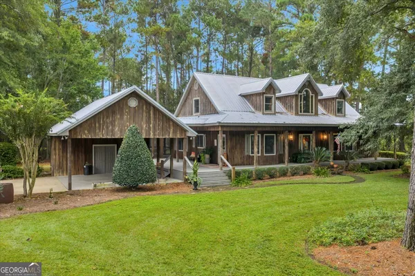 a front view of house with yard barbeque and outdoor seating