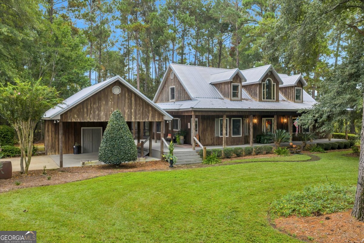 a front view of house with yard barbeque and outdoor seating