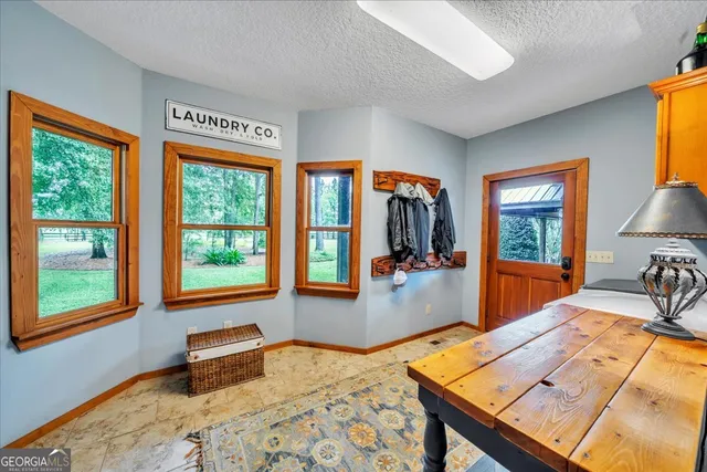 a hallway with a view of bedroom with furniture and a window