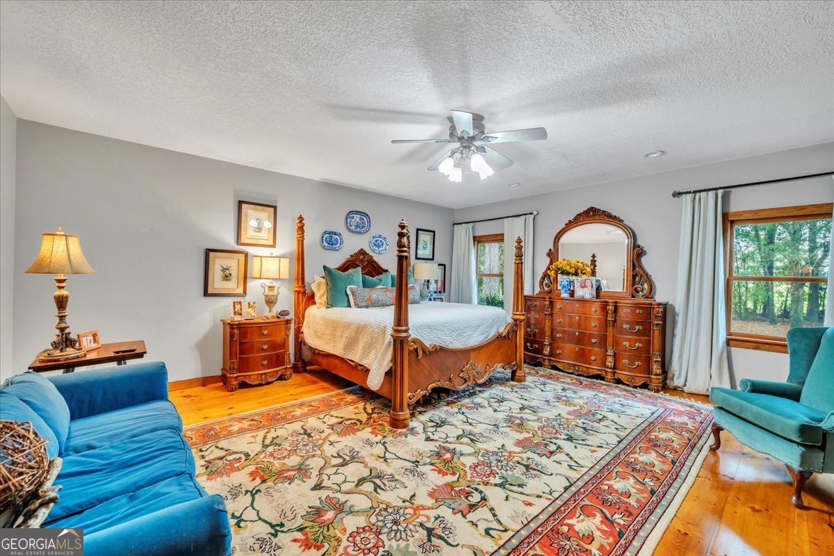 568 Hopewell Church Road Rhine, GA 31077 - Photo 18 of 77 a bedroom with a large bed and a chandelier