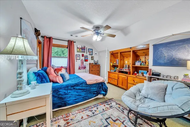 a view of a deck with wooden floor and roof with a garden view
