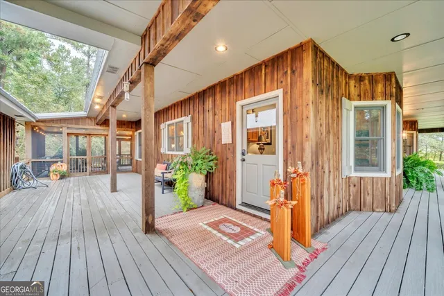 a porch with a table and chairs under an umbrella