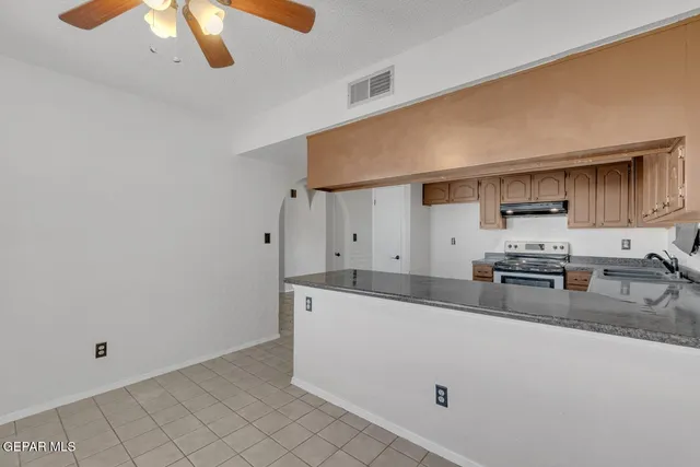 a kitchen with stainless steel appliances granite countertop a sink and a stove
